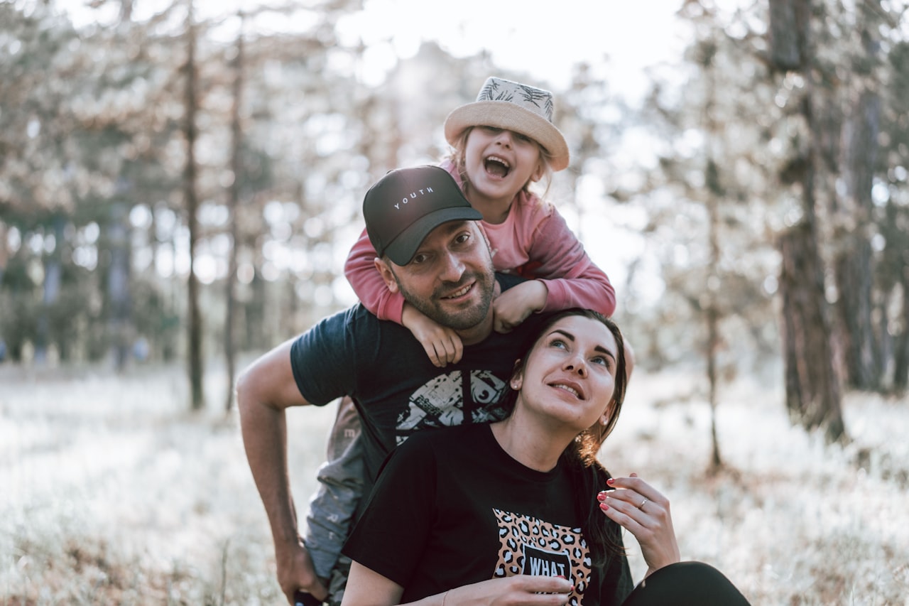 A parent carrying a child on their shoulders